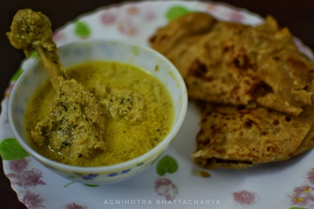 Picture of paratha with chicken in white curry.